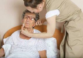 jovem social trabalhos assistente e Senior mulher dentro dela quarto foto