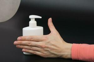 líquido Sabonete distribuidor e uma humano mão foto