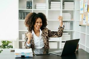 africano o negócio mulher estão Deleitado e feliz com a trabalhos elas Faz em seus tábua, computador portátil e levando notas às a escritório. foto