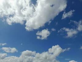 nuvens brancas no céu azul. lindo fundo azul brilhante. claro nublado, bom tempo. nuvens encaracoladas em um dia ensolarado. foto