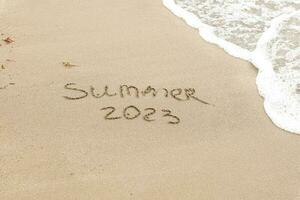 verão 2023 escrito em a areia foto