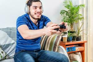 Visão do uma feliz jovem homem jogando a jogos foto