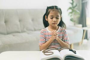 pequeno menina Rezar dentro a manhã.pequeno ásia menina mão orando, mãos guardada dentro oração conceito para fé, espiritualidade e religião. foto