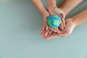 mãos segurando terra papel e água pintar. conceito do protegendo a mundo a partir de global aquecimento. sustentabilidade tema para Salve  a mundo. foto