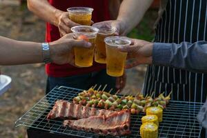 Cerveja bebidas preparado para churrasco festa entre amigos estão servido dentro plástico óculos Porque plástico óculos pode estar facilmente armazenado às fim do Festa. fácil festa idéia de servindo Cerveja dentro plástico óculos. foto