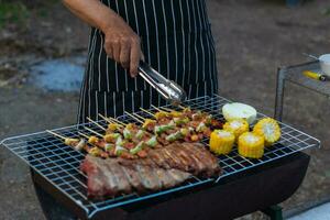 carne e espetos ingredientes para churrasco festa estão colocada em grade para cozinhar churrasco e faço isto pronto para família para Junte-se churrasco festa essa noite. festa fundo imagem tem cópia de espaço para texto. foto