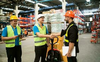 industrial armazém Gerente engenheiro trabalhador dentro segurança suíte aperto de mão comemoro bem sucedido ou acordo compromisso. logística , fornecem cadeia e armazém negócios.trabalho em equipe unidade debaixo Visão conceito. foto