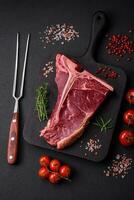 cru suculento carne t-bone bife com sal, especiarias e ervas foto