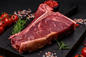 cru suculento carne t-bone bife com sal, especiarias e ervas foto