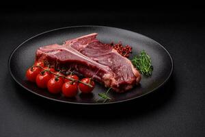 cru suculento carne t-bone bife com sal, especiarias e ervas foto