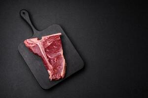 cru suculento carne t-bone bife com sal, especiarias e ervas foto