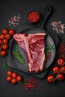 cru suculento carne t-bone bife com sal, especiarias e ervas foto