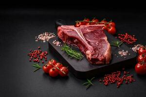 cru suculento carne t-bone bife com sal, especiarias e ervas foto