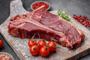 cru suculento carne t-bone bife com sal, especiarias e ervas foto