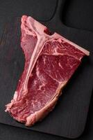 cru suculento carne t-bone bife com sal, especiarias e ervas foto