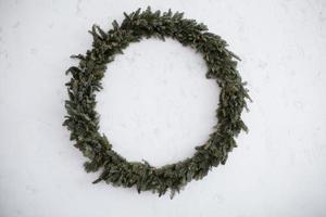 grande guirlanda de Natal é isolada em um fundo branco de pedra coroa de flores verde redonda. decoração natural. feriados. tradições. foto