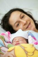 recém-nascido menina com dela mãe dentro a hospital em a dia do dela aniversário. maternidade conceito foto