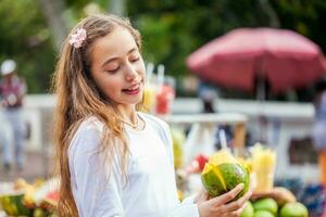 lindo jovem menina às paseo bolivar quadrado dentro a cidade do cali comendo tropical frutas dentro Colômbia foto