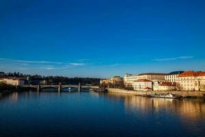 dourado luz sobre a lindo velho Cidade do Praga cidade durante pôr do sol às cedo Primavera visto a partir de Charles ponte foto