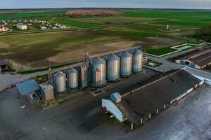 aéreo panorâmico Visão em agroindustrial complexo com silos e grão secagem linha para secagem limpeza e armazenamento do cereal cultivo foto