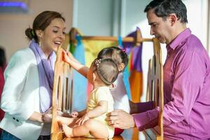 lindo dez meses bebê menina jogando com dela família. cedo estimulação para crianças conceito. foto