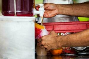 rua fornecedor dentro a cidade do cali dentro Colômbia preparando e vendendo uma tradicional doce água gelo chamado cholado foto