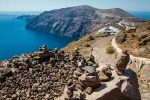 cairns do pedras às a caminhando caminho número 9 entre a cidades do fira e oia às santorini ilha foto