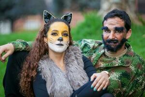 jovem casal vestindo Lobo e lenhador figurinos. real família tendo Diversão enquanto usando fantasias do a pequeno vermelho equitação de capuz conto dentro dia das Bruxas. foto