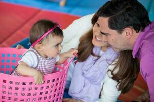 lindo dez meses bebê menina jogando com dela pais. cedo estimulação para crianças conceito. foto