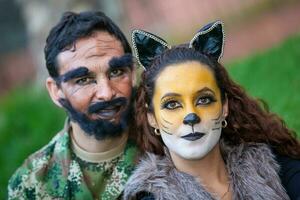 jovem casal vestindo Lobo e lenhador figurinos. real família tendo Diversão enquanto usando fantasias do a pequeno vermelho equitação de capuz conto dentro dia das Bruxas. foto