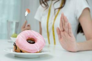 dieta e dieta. corpo feminino magro de beleza confunde rosquinha. mulher em roupas de ginástica atinge meta de perda de peso para uma vida saudável, louca por magreza, cintura fina, nutricionista. foto