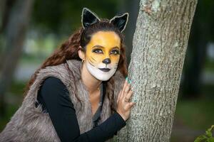 lindo jovem mulher vestindo uma Lobo fantasia. real família tendo Diversão enquanto usando fantasias do a pequeno vermelho equitação de capuz conto dentro dia das Bruxas. foto