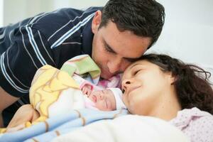 jovem mãe e pai com seus recém-nascido bebê menina às a hospital em a dia do dela aniversário. família conceito. paternidade conceito foto