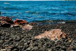 detalhe do a pedras em a famoso vermelho de praia às santorini ilha dentro uma lindo cedo Primavera dia foto