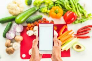 Veja para uma receita em a Internet com Móvel telefone Sediada em vegetal ingredientes foto