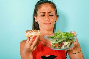 mulher pensa para comer rosquinhas em vez de do uma salada foto