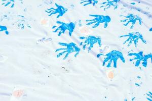 a Bêbês mão mancha em a branco tela de pintura superfície. foto
