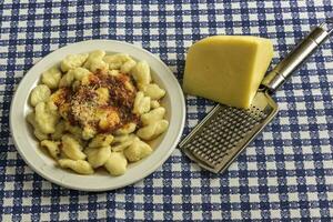 prato do caseiro nhoque com Grato queijo em a mesa foto