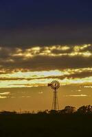 panorama com moinho de vento às pôr do sol, pampas, Patagônia, Argentina foto