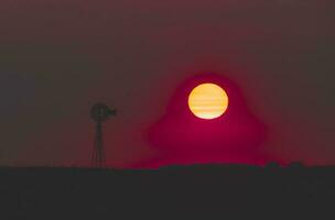 moinho de vento dentro campo às pôr do sol, pampas, Patagônia, Argentina. foto