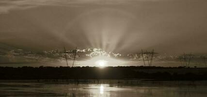 Alto Voltagem poder linha às pôr do sol, pampas, Argentina foto