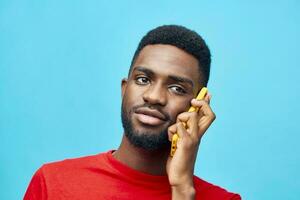 homem tecnologia Preto fundo telefone Móvel africano feliz vermelho digitando sorrir jovem foto