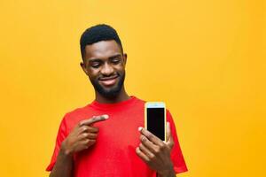 africano homem telefone jovem feliz tecnologia Móvel fundo telefone estúdio Preto amarelo Móvel foto