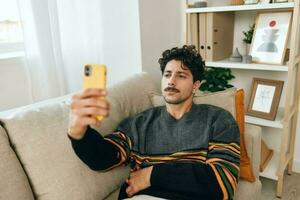 tecnologia homem telefone mensagem caucasiano casa estilo de vida digitando casual selfie comunicação sofá foto