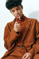 moda homem fumar sentado cigarro retrato fundo bege foto