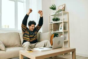 computador portátil homem sorrir casa trabalhando sofá computador conectados o negócio freelance caderno foto