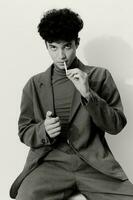 retrato homem estilo hipster cigarro luz aluna branco sentado fumar pensativo e elegante moda Preto foto