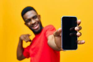 jovem homem tecnologia fundo Preto Móvel cara amarelo telefone africano colorida feliz foto