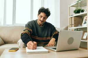 computador homem casa conectados computador portátil trabalhando freelance bonito sorrir sofá o negócio foto