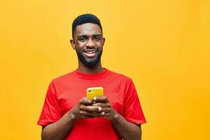 homem amarelo jovem africano mostrando Móvel cópia de telefone tecnologia fundo feliz Preto espaço foto